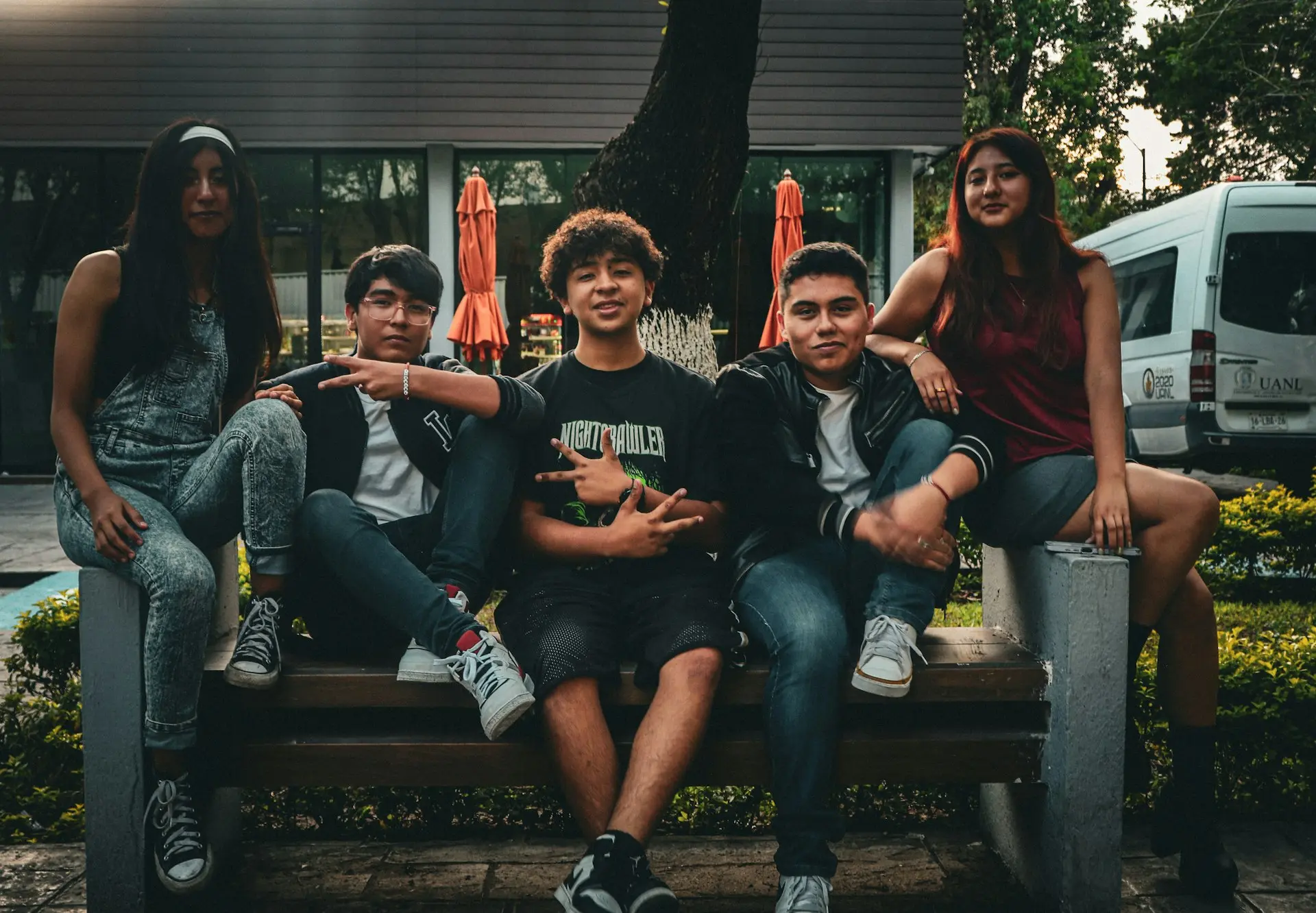 A group of people sitting on top of a wooden bench